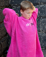 Dryrobe Handtuchmantel Bio Kids in Magenta, Junge trägt Bademantel aus Bio-Baumwolle mit Logo-Print