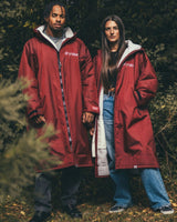 Dryrobe Advance Long Sleeve in Burgundy mit Sherpa-Futter, getragen von zwei Personen in Außenumgebung