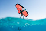 Duotone Unit 2027 Kite in Rot-Schwarz, Kitesurfer hält Lenkdrachen über Wasser, Frontalansicht