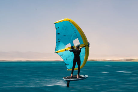 Duotone Unit D/LAB 2027 Windsurfegel blau-gelb, Sportler auf Board im Wasser von vorne