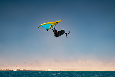 Duotone Unit D/LAB 2027 Kiteboard Gelb-Blau in Aktion über dem Wasser, Frontalansicht