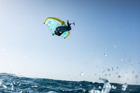 Duotone Unit D/LAB 2027 Kiteschirm in Hellblau und Gelb mid-air über dem Wasser beim Kitesurfen