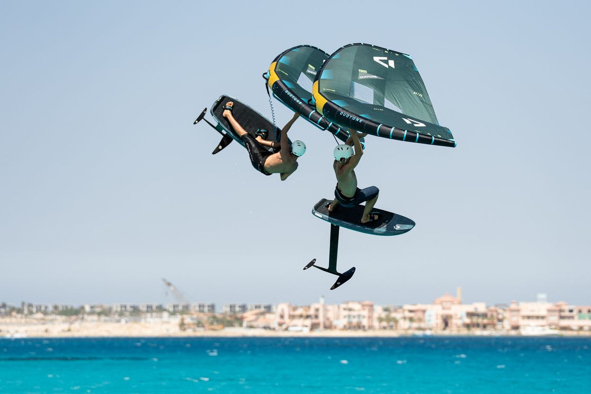 Duotone Unit SLS 2027 Kiteboard grün-schwarz im Sprung über türkisblauem Meer, Frontalansicht