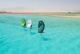 Duotone Unit SLS 2027 Kite in Grün, Weiß und Dunkelgrün, aufgereiht im türkisen Wasser, Frontansicht