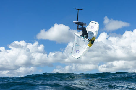 Duotone Unit SLS Concept Blue 2027 Kiteboard weiß-blau in Aktion über Wasser, Sprungperspektive