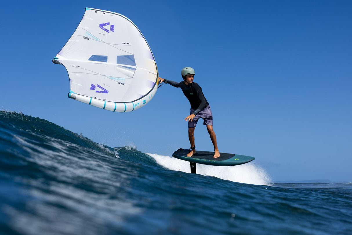 Duotone Unit SLS Concept Blue 2027 Kiteboard weiß-blau in Aktion auf dem Wasser, Fahrer auf Board mit gespanntem Segel