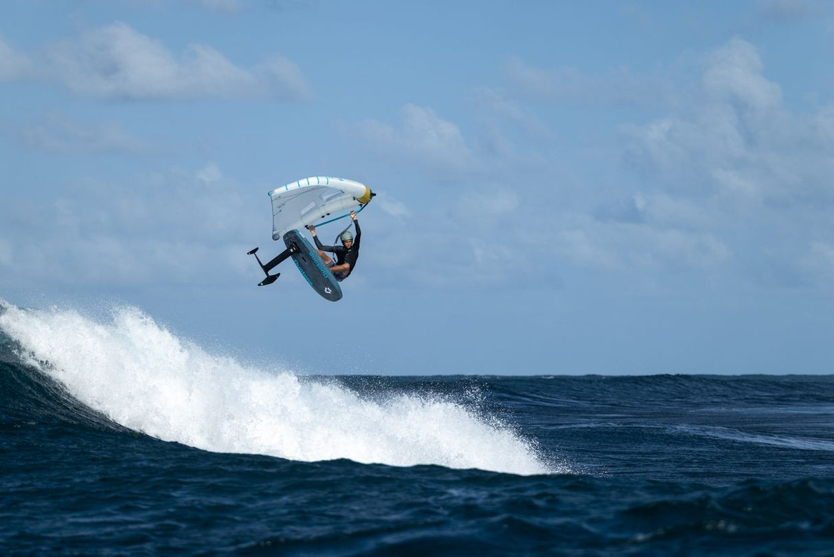 Duotone Sky Style SLS 2027 Kiteboard in Weiß und Blau, Sprung über Welle im Meer