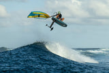 Duotone Sky Style SLS 2027 Kiteboard mit blauem und gelbem Design in Aktion über Welle, Sportperspektive
