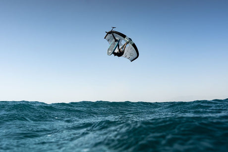 Duotone Sky Style SLS 2027 Kiteboard in Aktion über Wellen, Luftaufnahme mit klarem Himmel