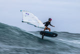 Duotone Sky Style SLS 2027 Wingsail Foilboard mit weißem Segel, Athlet beim Wingfoilen auf dem Wasser