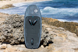 Duotone Sky Style SLS 2027 Kiteboard in Grau, Draufsicht auf Felsen am Strand mit Meereshintergrund