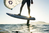 Kitesurfer mit Duotone Sky Style 2027 Kite und blauem Board im Wasser, Frontalansicht bei Sonnenuntergang