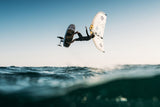 Kitesurfer in Aktion mit weißem Duotone Sky Style 2027 Kite über Wellen, Sprung aus Wasserperspektive