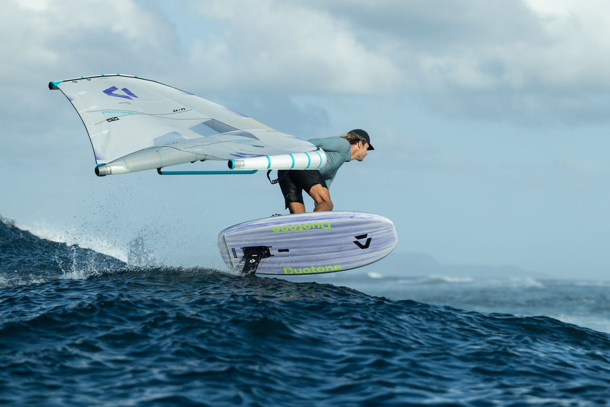 Duotone Sky Style 2027 Windsurfboard in Blau-Weiß, Athlet in Aktion auf dem Wasser, seitliche Ansicht