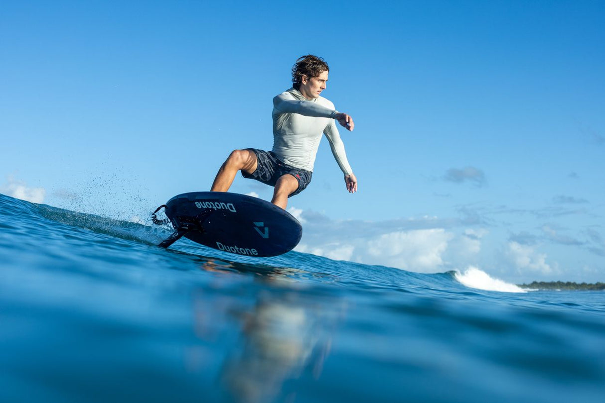 Duotone Crush SLS 2027 Kiteboard in Blau und Weiß, Fahrer auf Welle im Wasser von vorne
