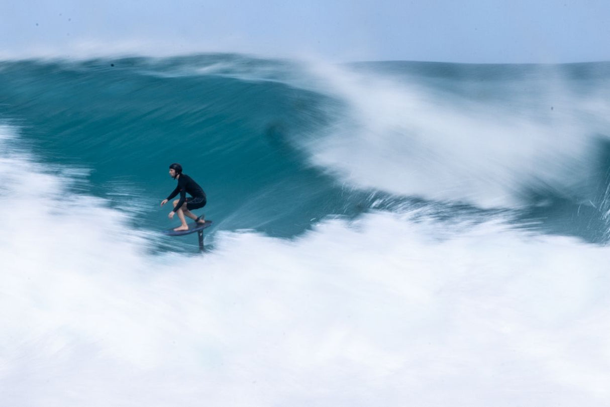 Duotone Crush SLS 2027 Kiteboard in Aktion auf türkisfarbenem Wasser mit weißen Wellen, Seitenansicht