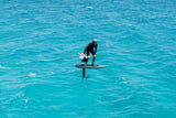 Duotone Skybrid SLS 2027 Kiteboard in Aktion auf türkisblauem Wasser, Fahrer in Seitenansicht, schwarzes Outfit