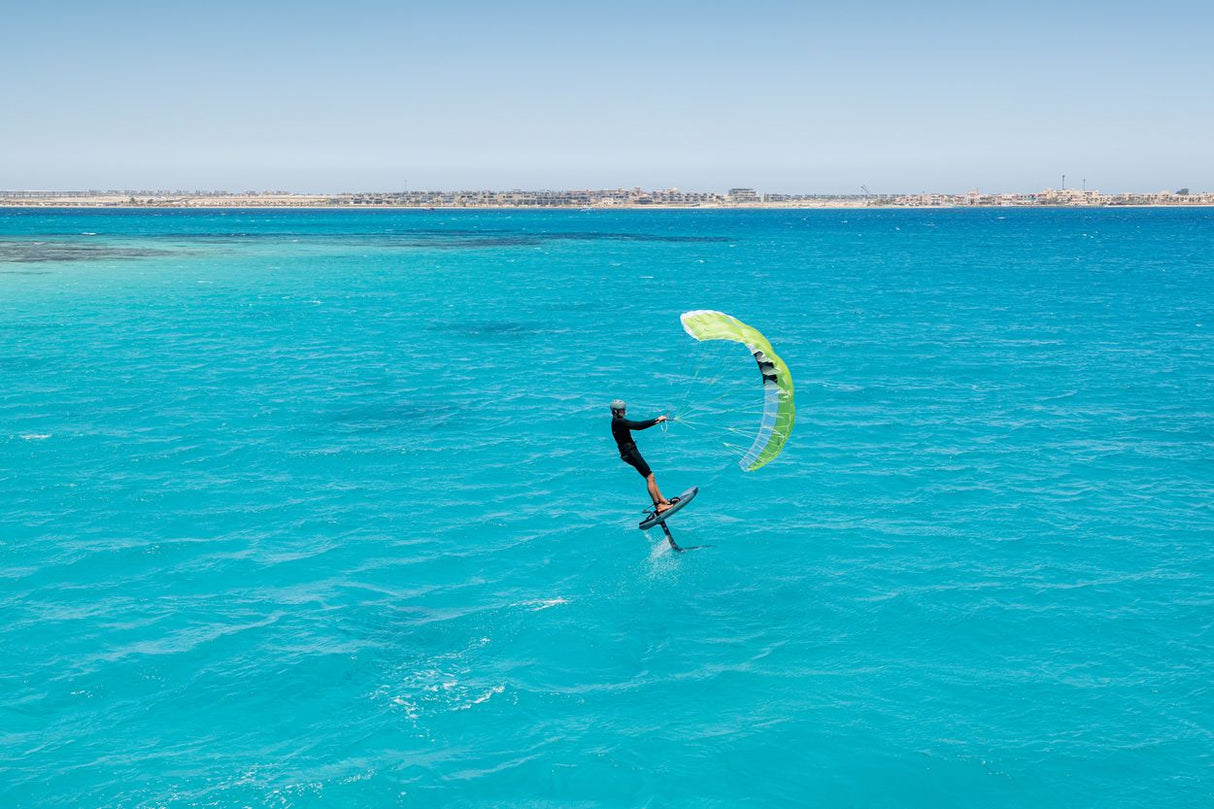 Duotone Skybrid SLS 2027 Kitesegel in Gelb-Grün, Kitesurfer in türkisblauem Wasser von oben