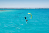 Duotone Skybrid SLS 2027 Kitesegel in Gelb-Grün, Kitesurfer in türkisblauem Wasser von oben