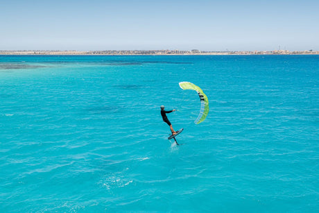 Duotone Skybrid SLS 2027 Kitesegel in Gelb-Grün, Kitesurfer in türkisblauem Wasser von oben