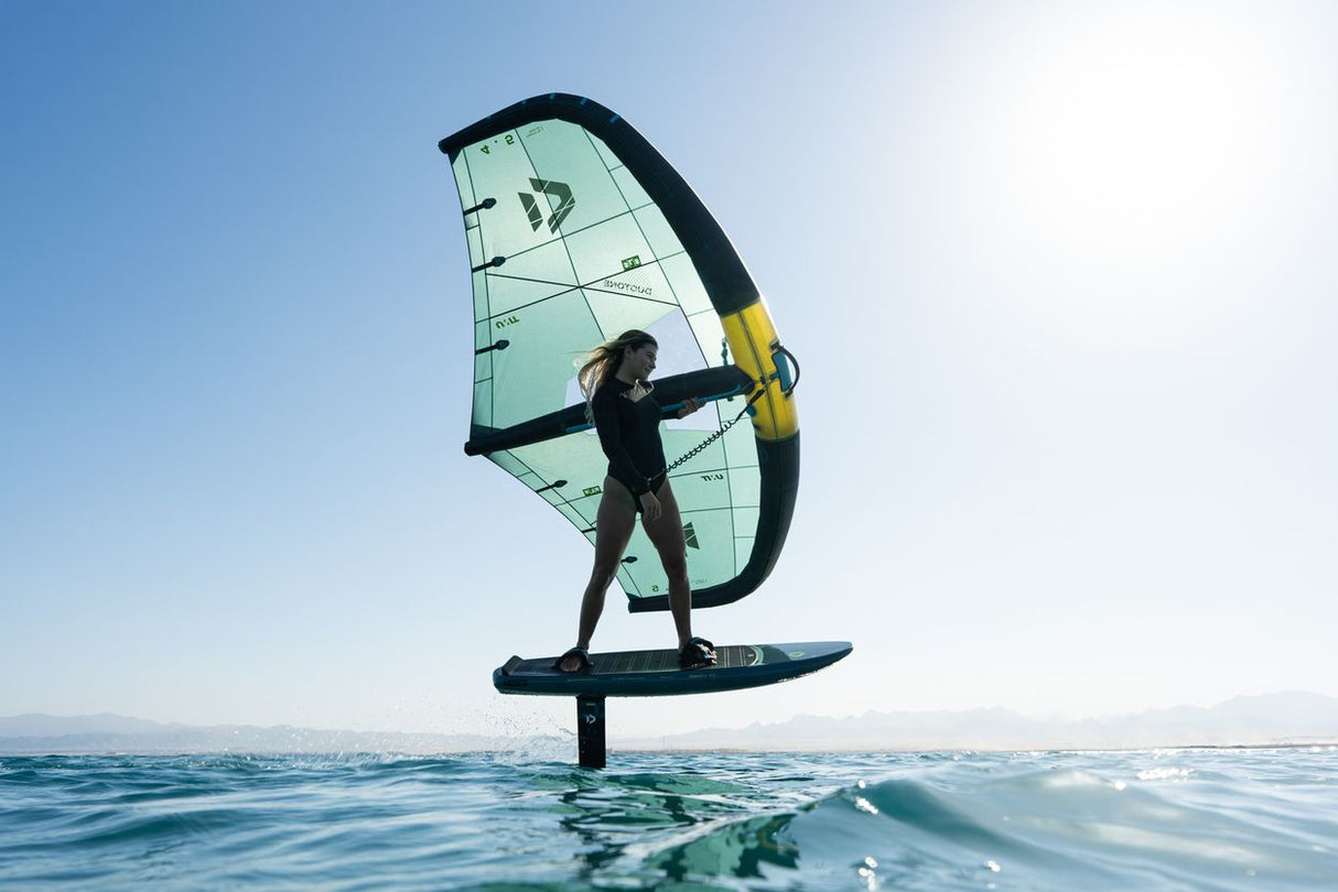 Duotone Skybrid SLS 2027 Kite mit schwarzem Rahmen und türkisem Segel, Kitesurfer auf Board im Wasser