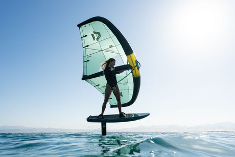 Duotone Skybrid SLS 2027 Kite mit schwarzem Rahmen und türkisem Segel, Kitesurfer auf Board im Wasser