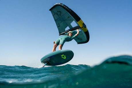 Duotone Skybrid SLS 2027 Kiteboard in Grün und Schwarz mit Fahrer in Aktion auf dem Wasser, Frontalansicht