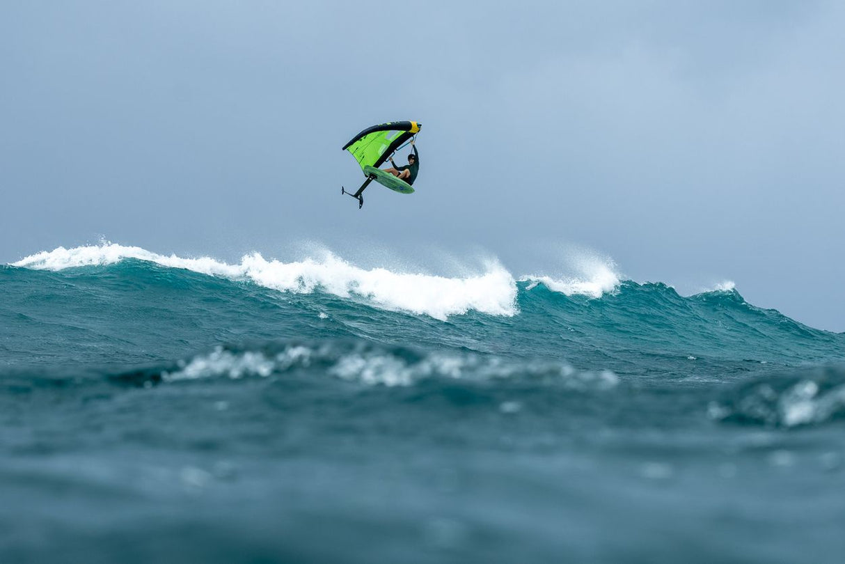 Duotone Trace SLS 2027 Kite in Neongelb und Schwarz beim Kitesurfen über Wellen