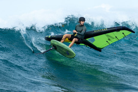 Duotone Trace SLS 2027 Kiteboard in Neongrün und Schwarz, Kitesurfer auf Welle in Aktion