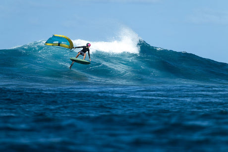 Duotone Trace SLS 2027 Kiteboard in Gelb-Blau, Surfer auf Welle im Meer