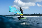 Duotone Trace SLS 2027 Windsurfboard türkis mit gelbem Mast, Athlet beim Windsurfen auf dem Wasser