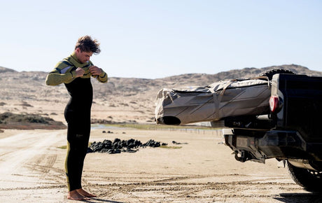 Duotone Combibag 2027 in Schwarz und Grün, Sporttasche mit Trageschlaufen, Frontalansicht bei Outdoor-Nutzung am Strand