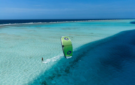 Duotone Neo SLS 2027 Kiteboard grün-schwarz, Draufsicht auf Kitesurfer im türkisen Wasser