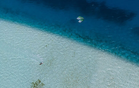 Duotone Neo SLS 2027 Kiteboard Luftaufnahme über türkisblauem Wasser und Sandstrand