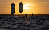 Duotone Evo D/LAB 2027 Kite in schwarzem Carbon-Material, aufgezogen über dem Meer bei Sonnenuntergang mit Kiter im Wasser