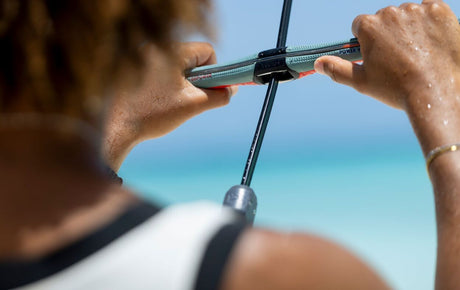 Duotone Click Bar Quad Control 2027 Kitebar in Grün und Schwarz, von vorne in Händen gehalten über Meer und Strand