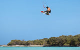 Duotone Vario Combo 2027 Kiteboard rot-schwarz in Aktion über türkisblauem Wasser, Sportperspektive