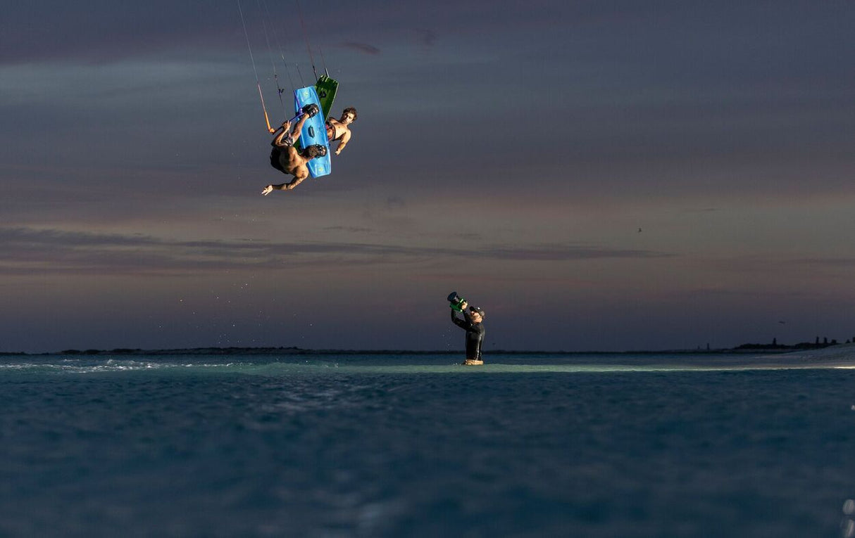 Duotone Select SLS 2027 Kiteboard in Blau-Schwarz, Kitesurfer in Aktion über dem Wasser, Seitenperspektive