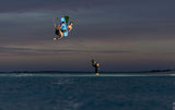 Duotone Select SLS 2027 Kiteboard in Blau-Schwarz, Kitesurfer in Aktion über dem Wasser, Seitenperspektive