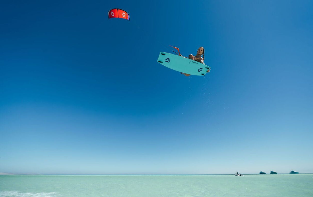 Duotone Soleil Concept Blue 2027 Kiteboard in Türkis, Kitesurfer in Aktion über tropischem Wasser, Draufsicht