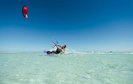 Duotone Soleil Concept Blue 2027 Kitesegel rot, Kitesurfer in türkisblauem Wasser, Frontalansicht