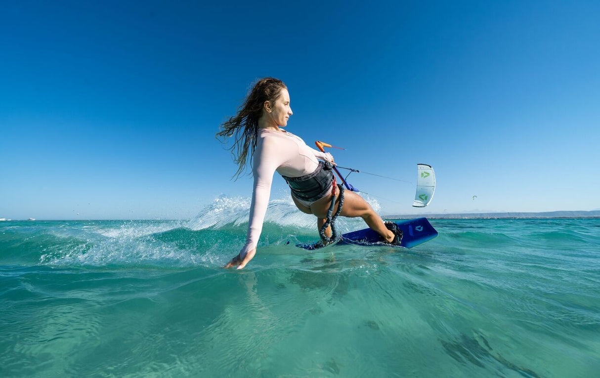 Duotone Soleil Concept Blue 2027 Kiteboard in blau, Seitenperspektive beim Kitesurfen im türkisfarbenen Meer