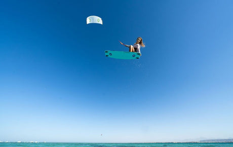 Duotone Soleil Concept Blue 2027 Kiteboard in Türkis, Athlet in Aktion über dem Meer, Draufsicht