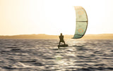 Duotone Soar SLS 2027 Kitesurfing-Lenkdrachen in Grün und Beige, in Aktion über dem Wasser mit Kitesurfer