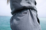 ION Tally 2.5 Boardshorts Damen in Grau, getragen am Meer, Detailansicht der Hüfte und Oberschenkel
