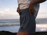 ION Tally 2.5 Boardshorts Damen marineblau, seitliche Detailansicht am Strand mit elastischem Bund