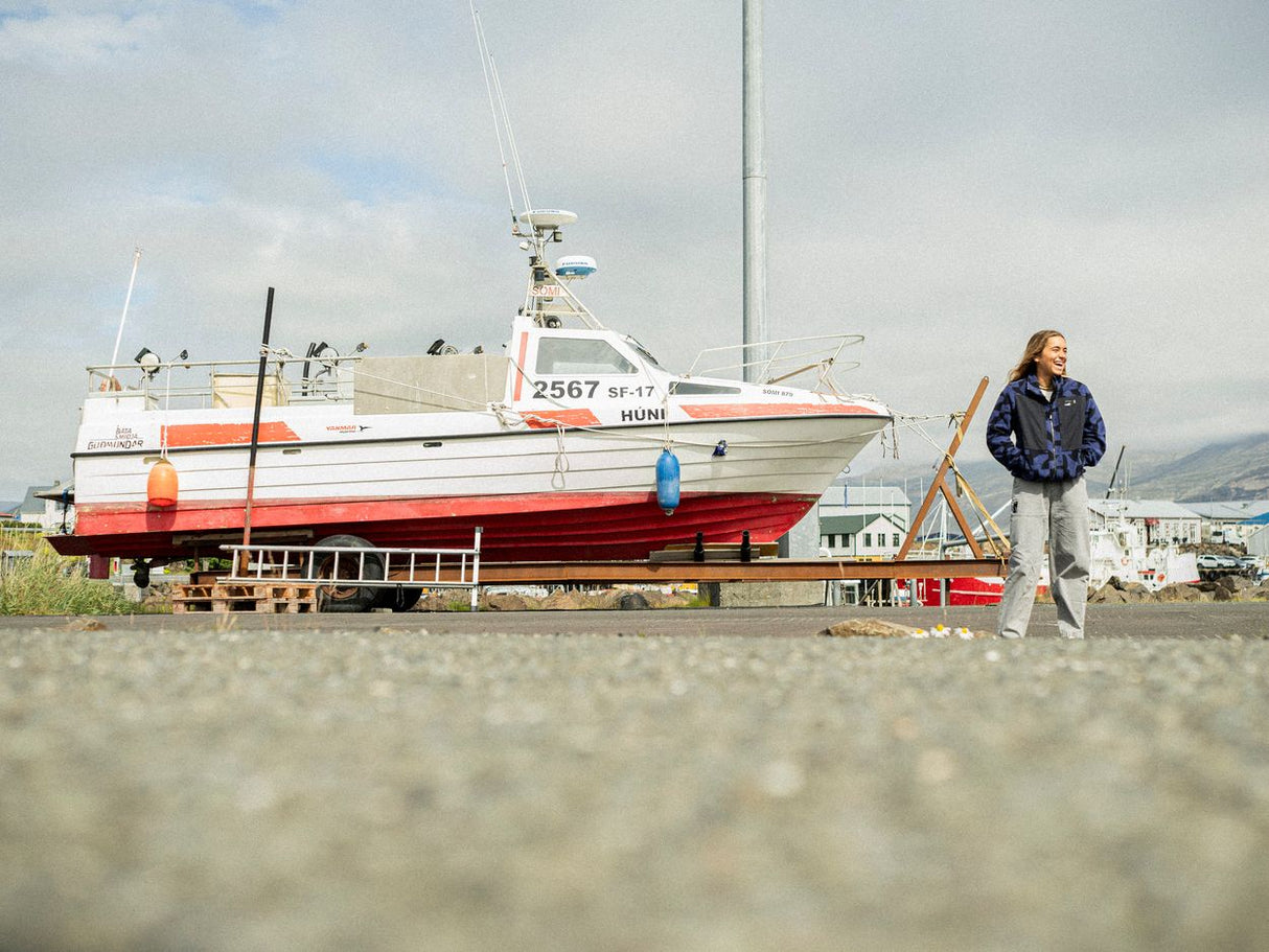 ION HD Cotton Hose 2026 in Dunkelblau, Frontalansicht auf Person am Strand neben Boot
