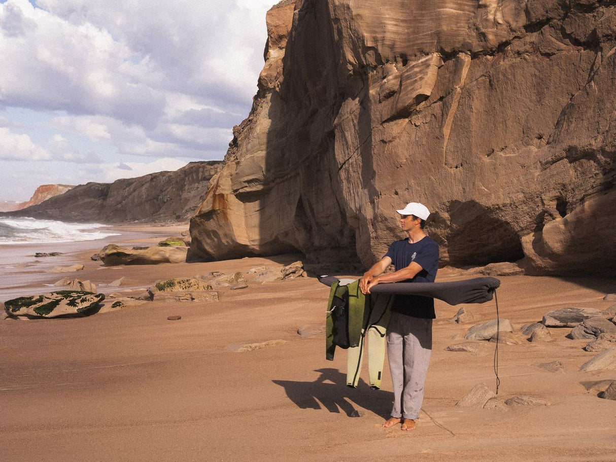 ION Pants HD Cotton 2026 in Hellgrau, Frontalansicht, Modell trägt Hose am Strand mit Felswand im Hintergrund
