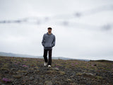 ION Surfing Elements Hoody 2026 in Blaugrau, Frontalansicht auf Person in bergiger Landschaft