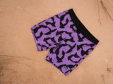 ION Boardshorts AOP 2026 in Violett mit schwarzem Allover-Print, Draufsicht am Strand